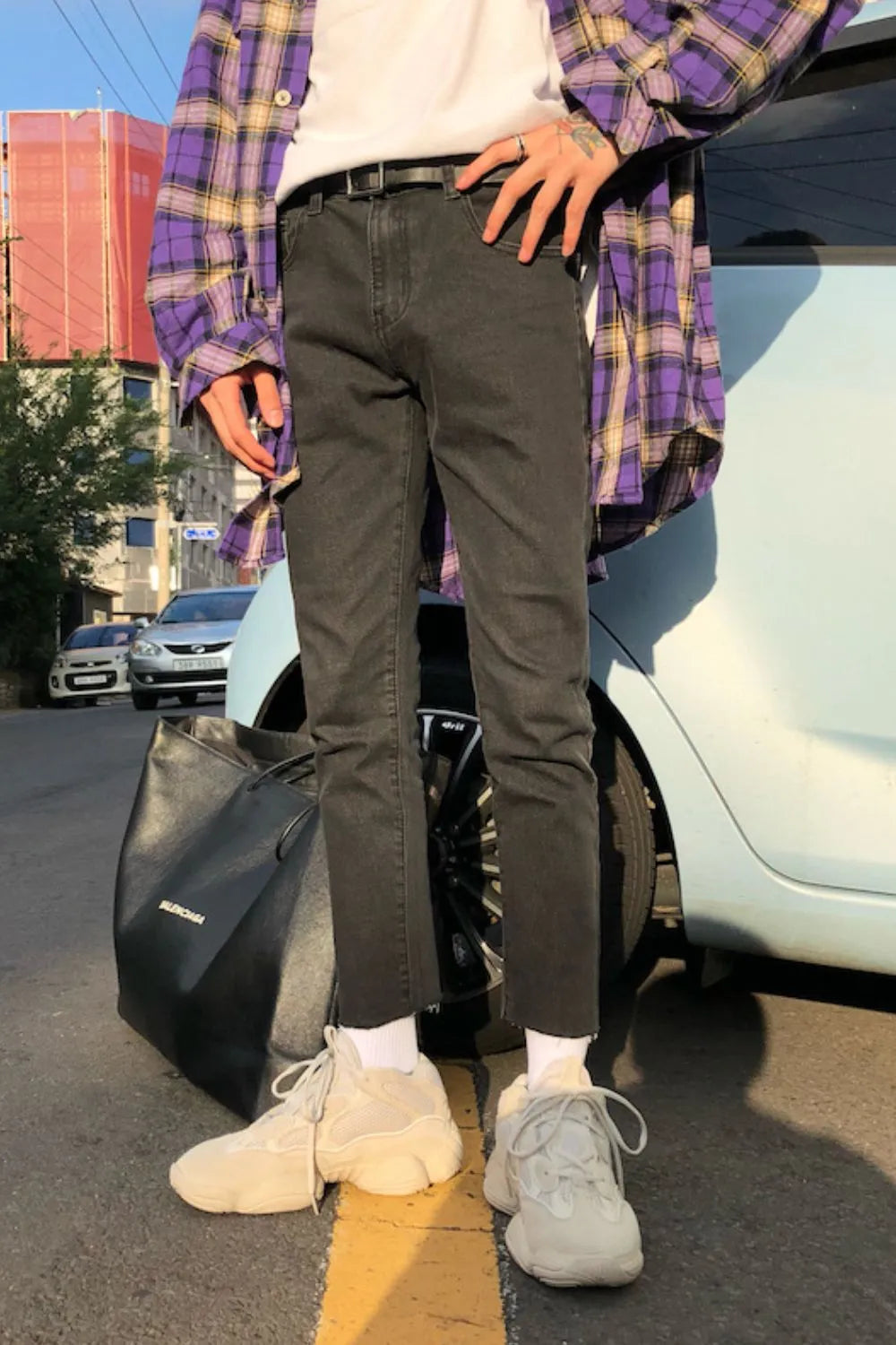 Dark washed denim slim-fit jeans with raw hem, styled casually.