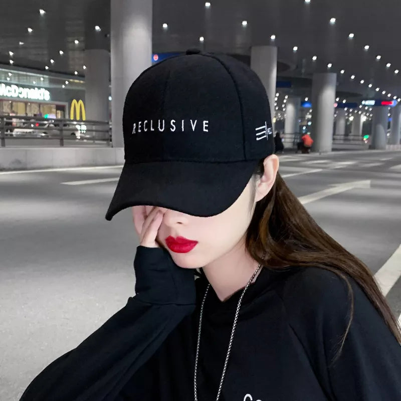 Black cotton baseball cap with white RECLUSIVE embroidery and side detail.