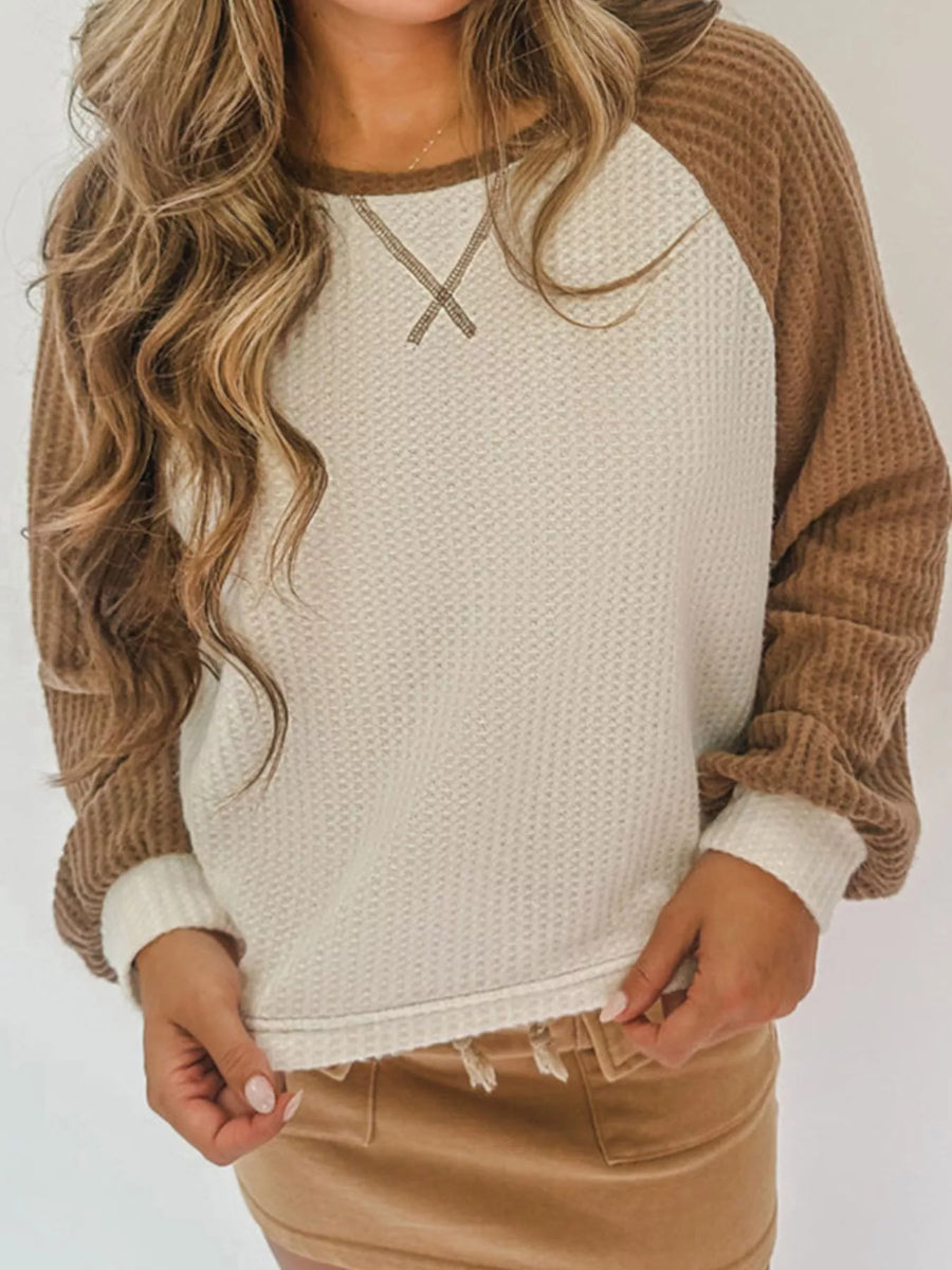 Beige waffle knit raglan sleeve sweater with contrast brown sleeves and X stitching detail.