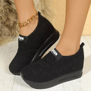Black textured round toe platform sneakers with elastic band and gold ankle chain.