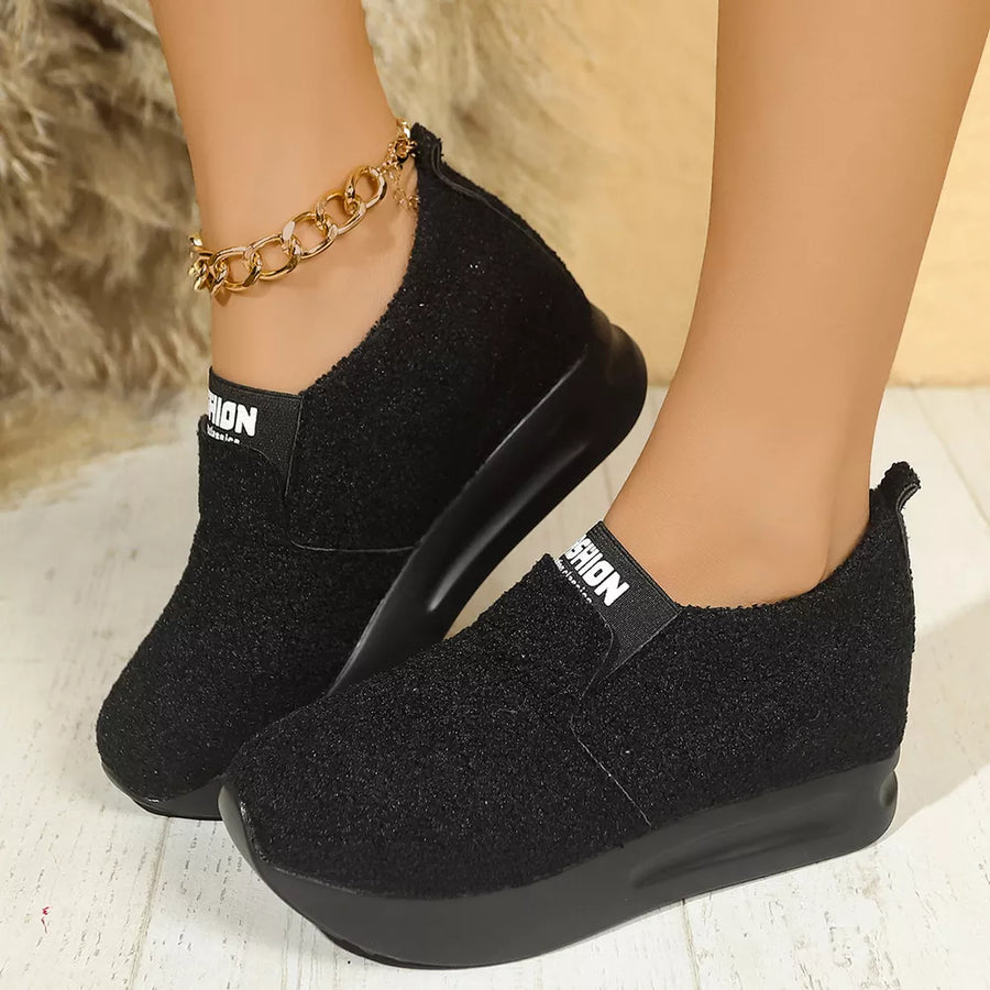 Black textured round toe platform sneakers with elastic band and gold ankle chain.