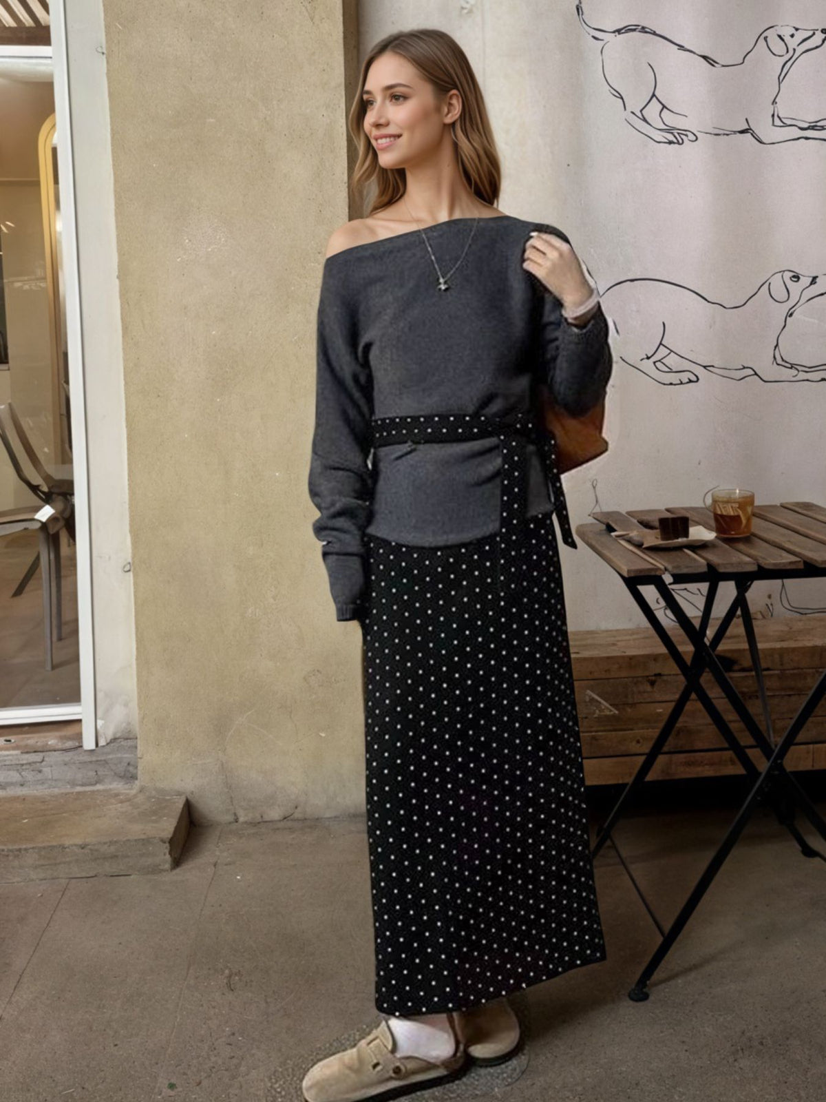 Black polka dot maxi skirt with a belted waist, paired with a grey off-the-shoulder top.