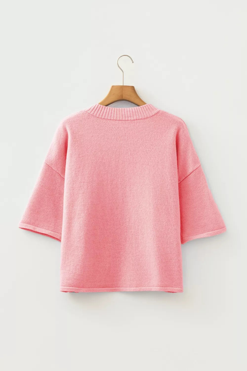 Pink boxy knit cardigan with short sleeves and crew neck, acrylic material.