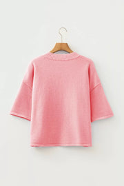 Pink boxy knit cardigan with short sleeves and crew neck, acrylic material.