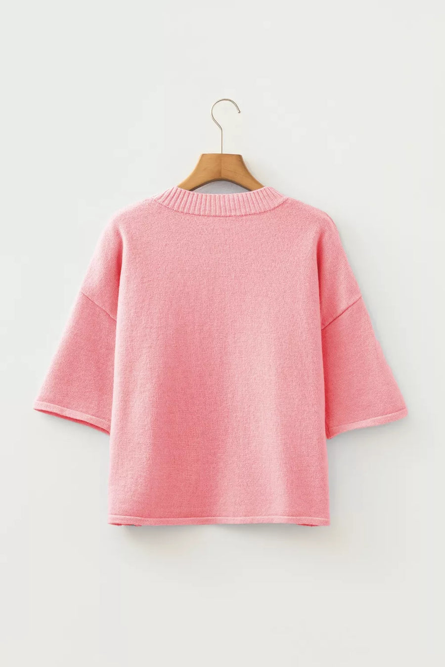 Pink boxy knit cardigan with short sleeves and crew neck, acrylic material.