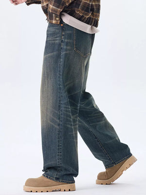 Men's relaxed fit wide-leg jeans in washed blue denim with a worn look.