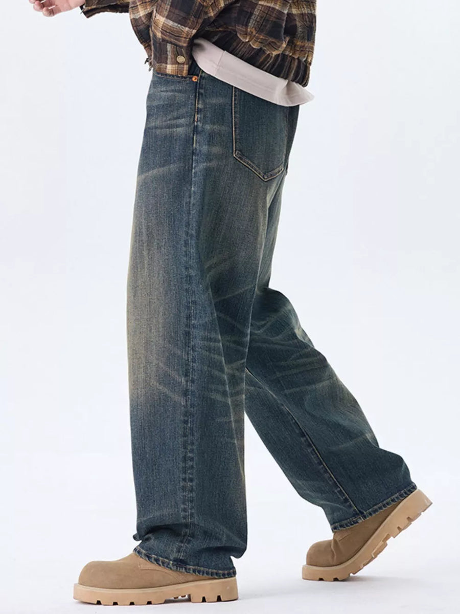 Men's relaxed fit wide-leg jeans in washed blue denim with a worn look.