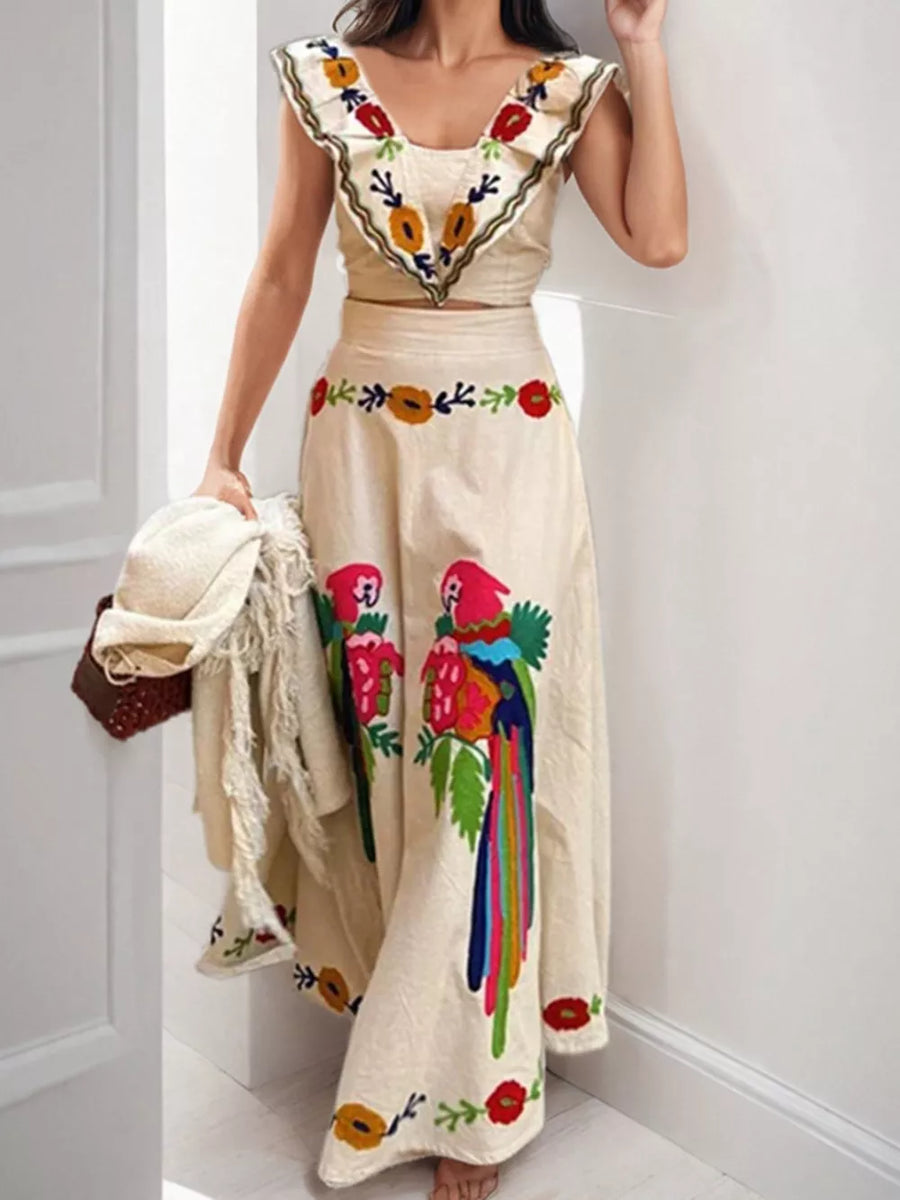 Cream maxi skirt with parrot embroidery and ruffled crop top with floral embroidery