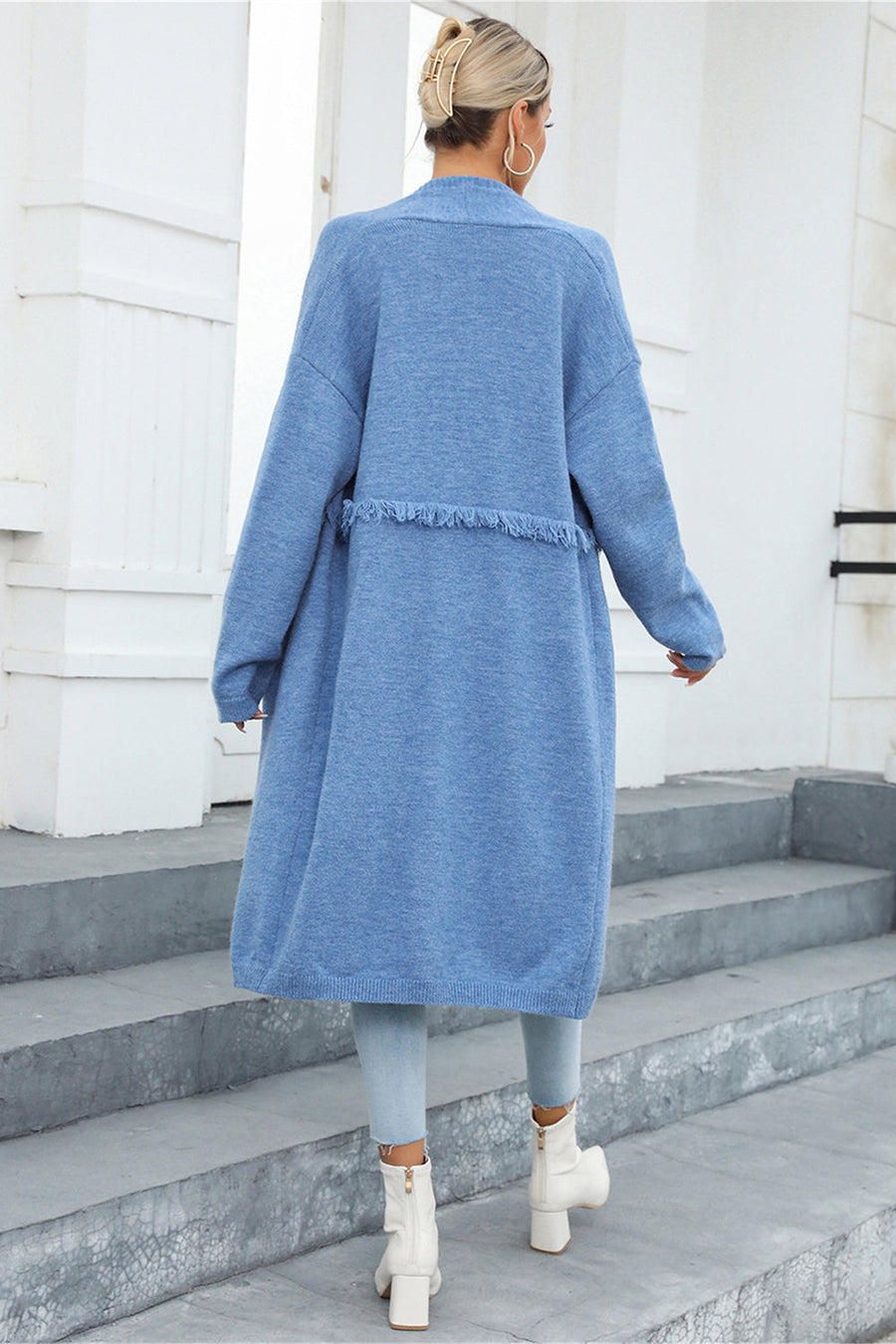 Light blue longline knit cardigan with fringe trim detail and relaxed fit.