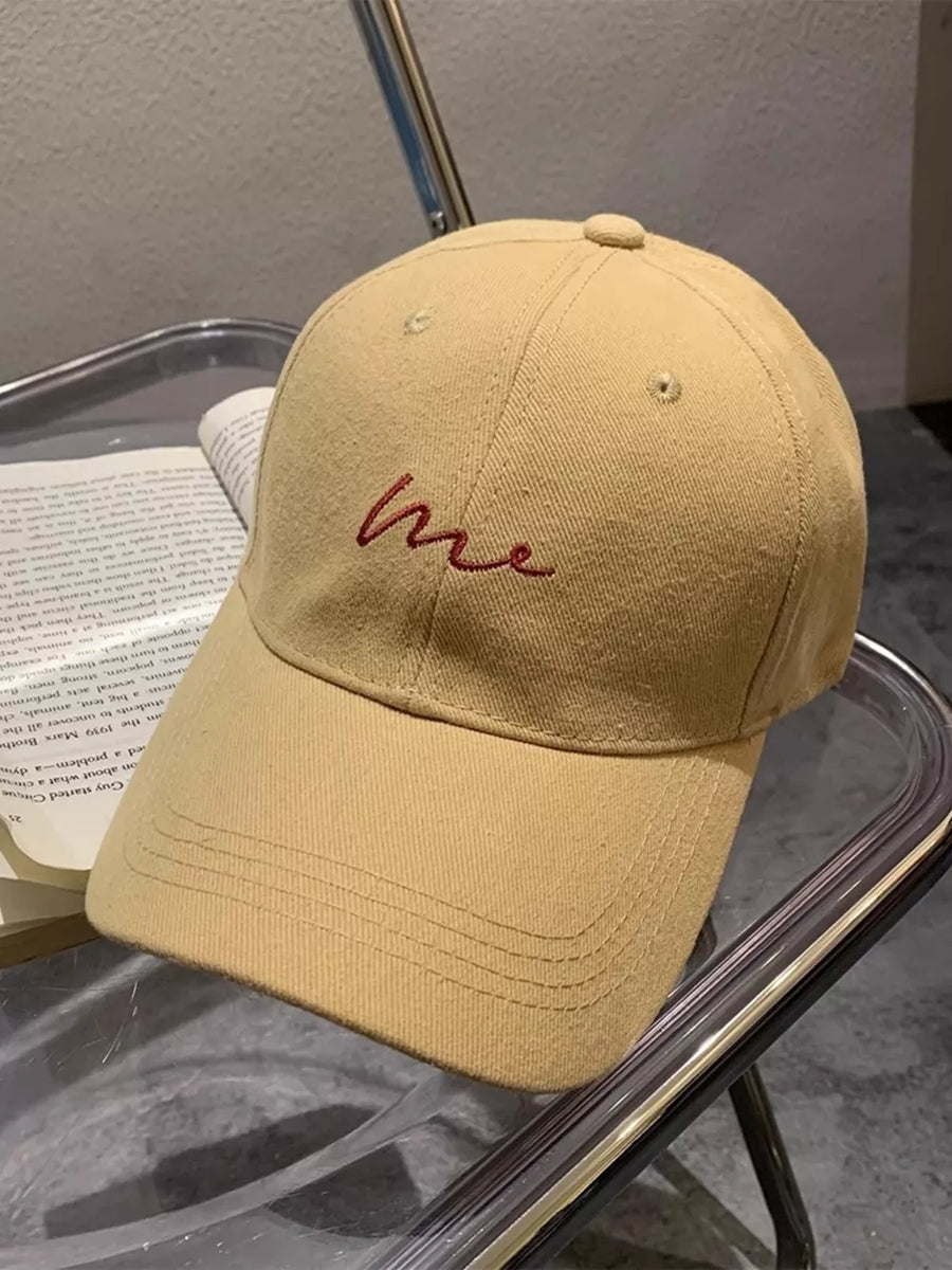 Khaki baseball cap with embroidered red 'me' text detail