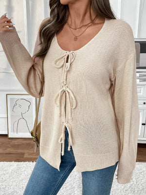 Cream knit cardigan with lace-up front detail and long sleeves.