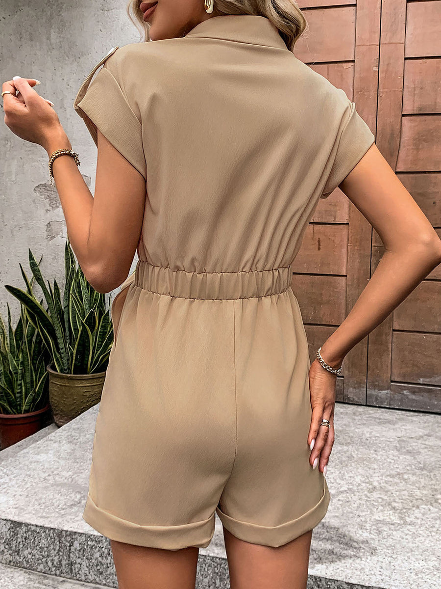 Camel utility romper with tie-waist detail, collared, short sleeves, and cuffed shorts.