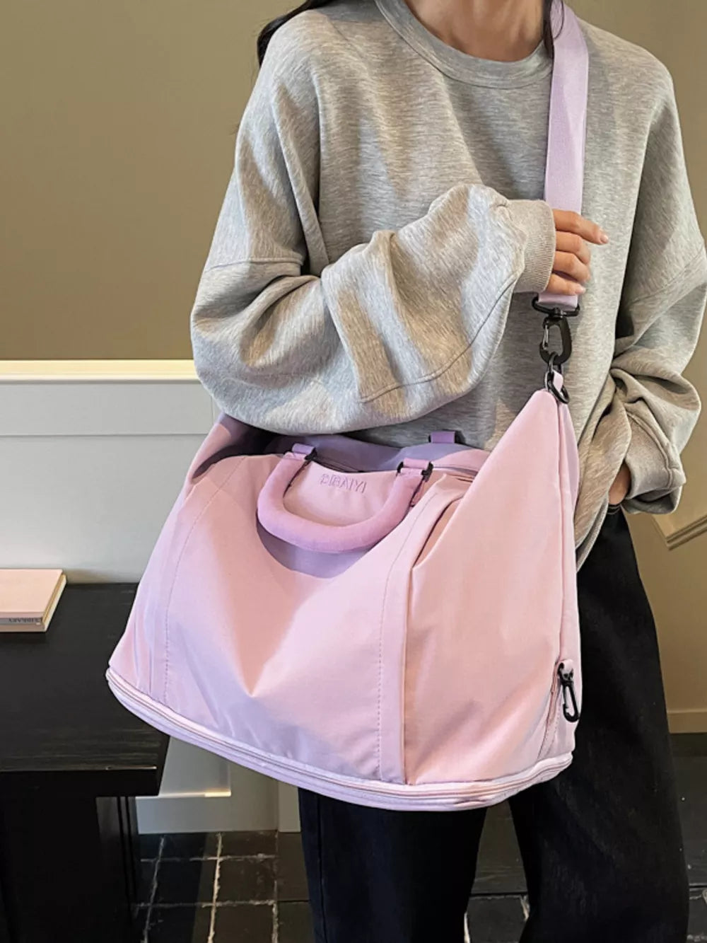 Sleek nylon travel bag in purple with adjustable strap and top handles.