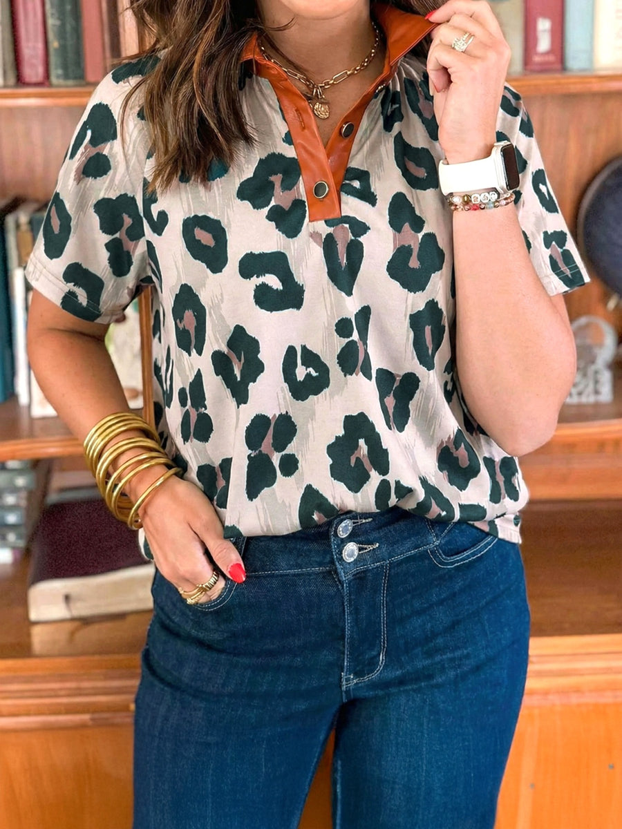 Print short sleeve blouse with animal print, brown collar, and button detail.