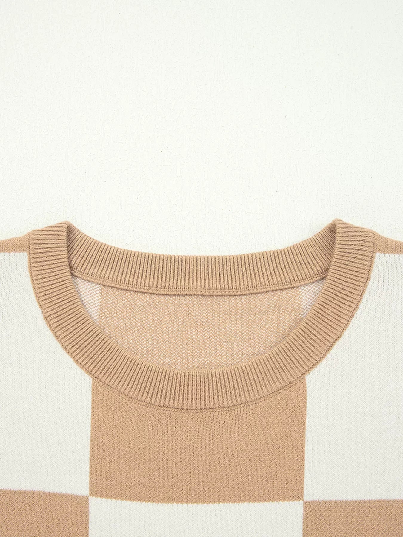 Drop shoulder sweater in camel and white checkerboard pattern with a ribbed crew neck.