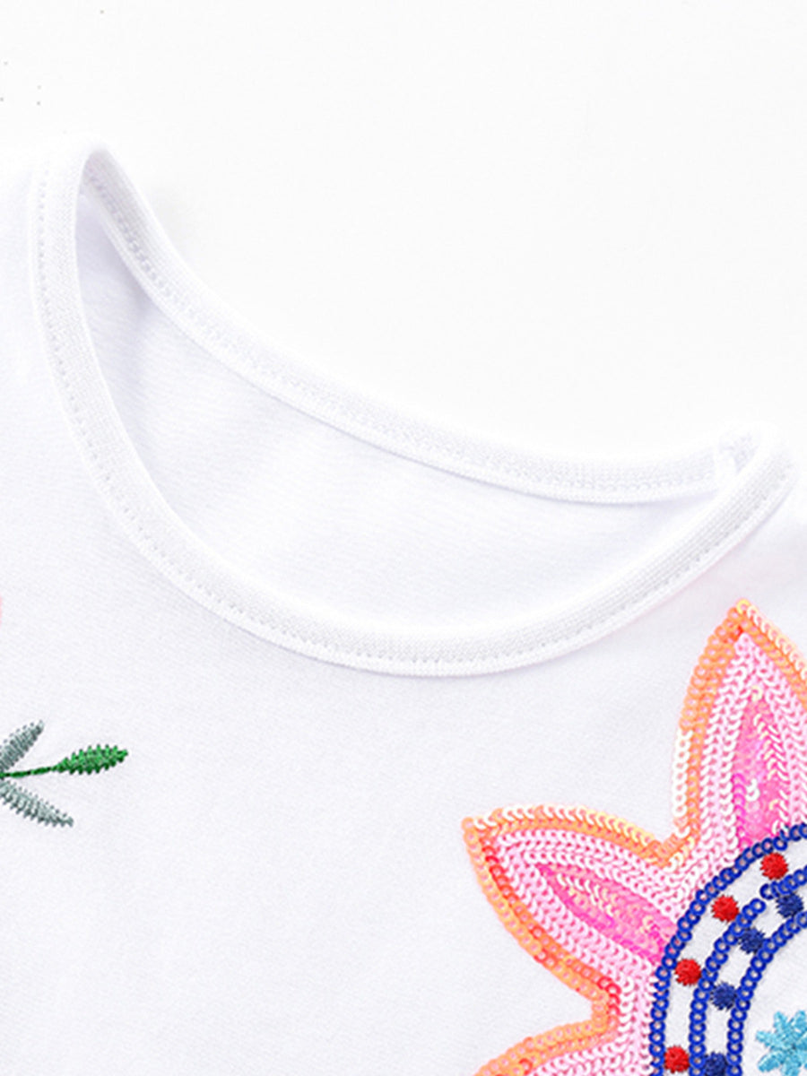 White cotton toddler dress with sequin flower applique and embroidered leaf detail.
