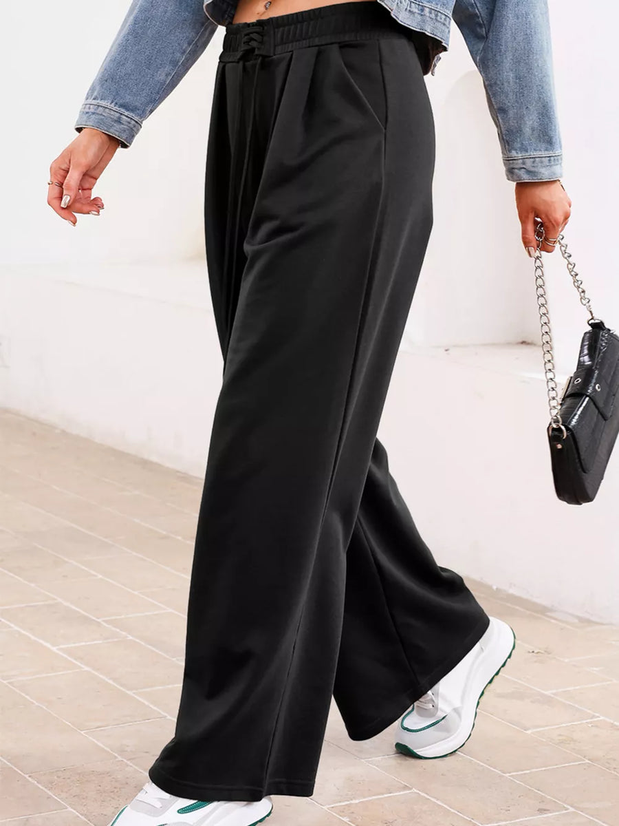 Black cotton drawstring high-waisted pleated maternity pants with a relaxed fit.