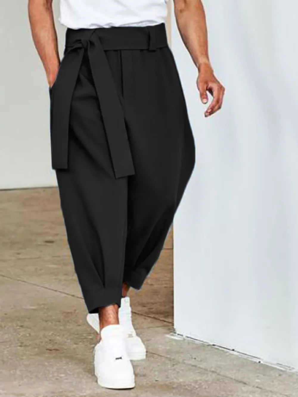 Black balloon-leg wrap trousers with a tie belt and cuffed hem.