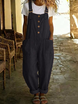 Black wide leg romper with button front, pockets and adjustable straps worn over a white tee.