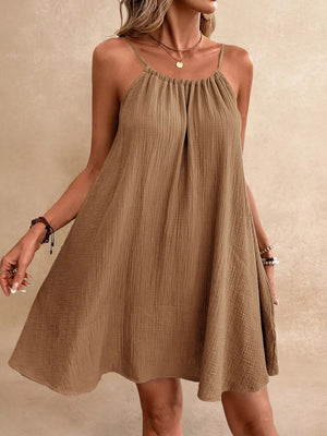 Light brown spaghetti strap gauze dress with textured fabric and gathered neckline.