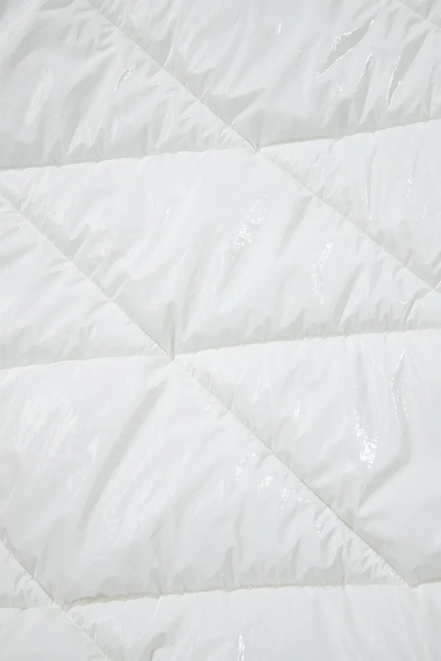 White glossy quilted puffer jacket detail with diamond stitching.