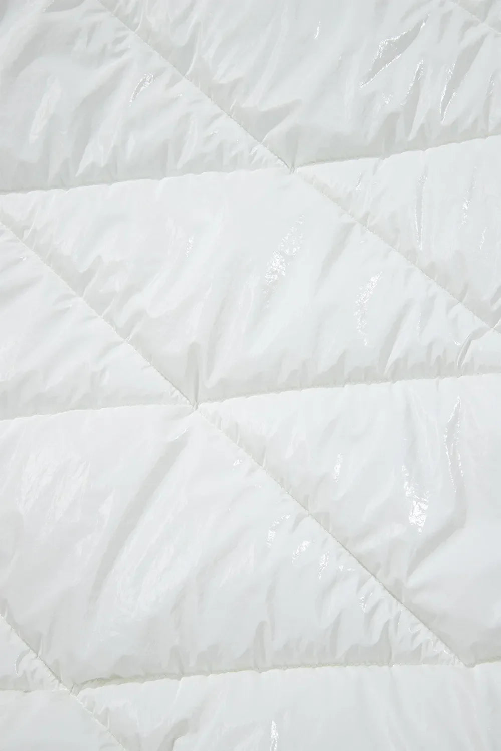 White glossy quilted puffer jacket detail with diamond stitching.