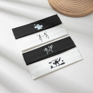 Spooky graphic headbands in black and white with ghost, skeleton, and black cat Halloween designs.