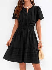 Black textured V-neck tiered dress with smocked waist and short sleeves.
