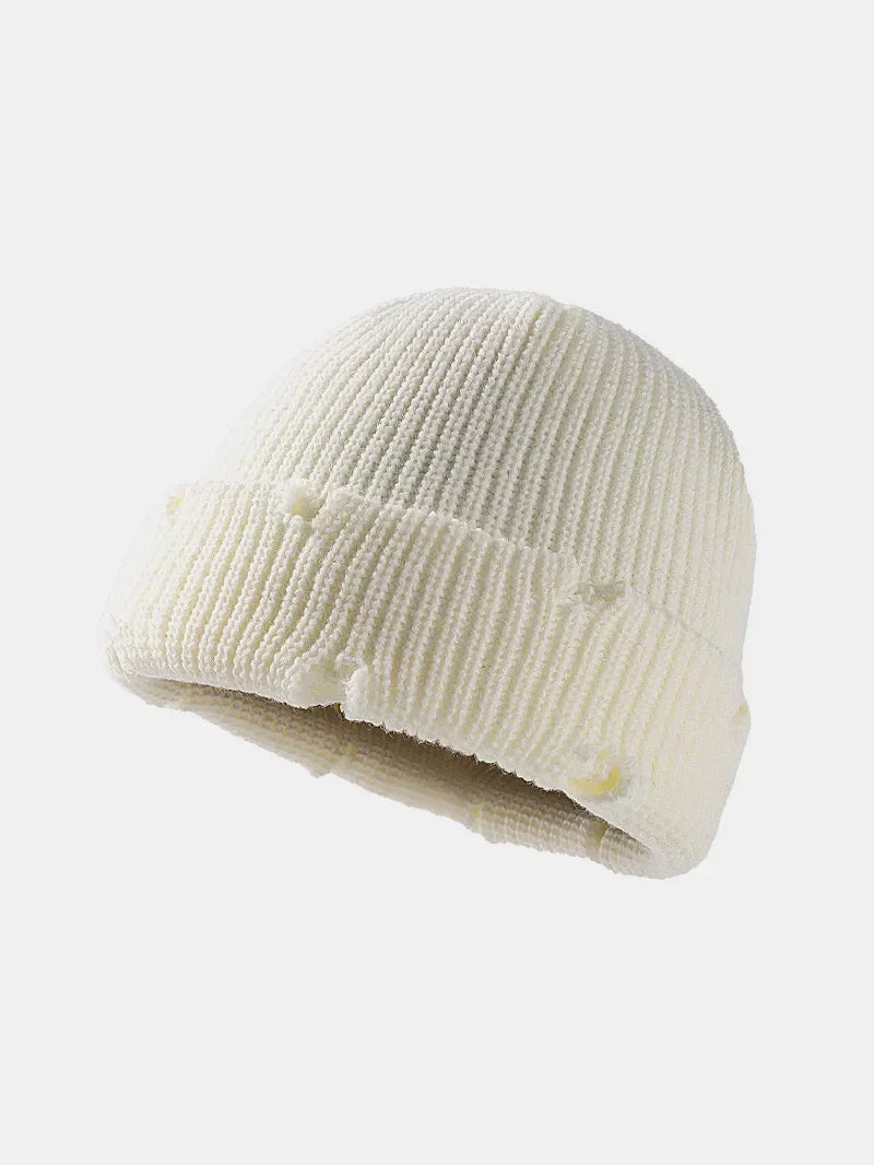 White ribbed knit beanie with distressed details and a cuffed hem.