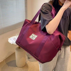 Deep purple duffel bag with a "Fashion" patch and dual straps, perfect for travel or gym.