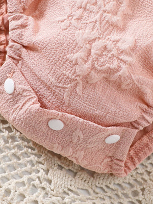 Pink floral embossed baby one-piece with white snaps, cotton blend fabric.