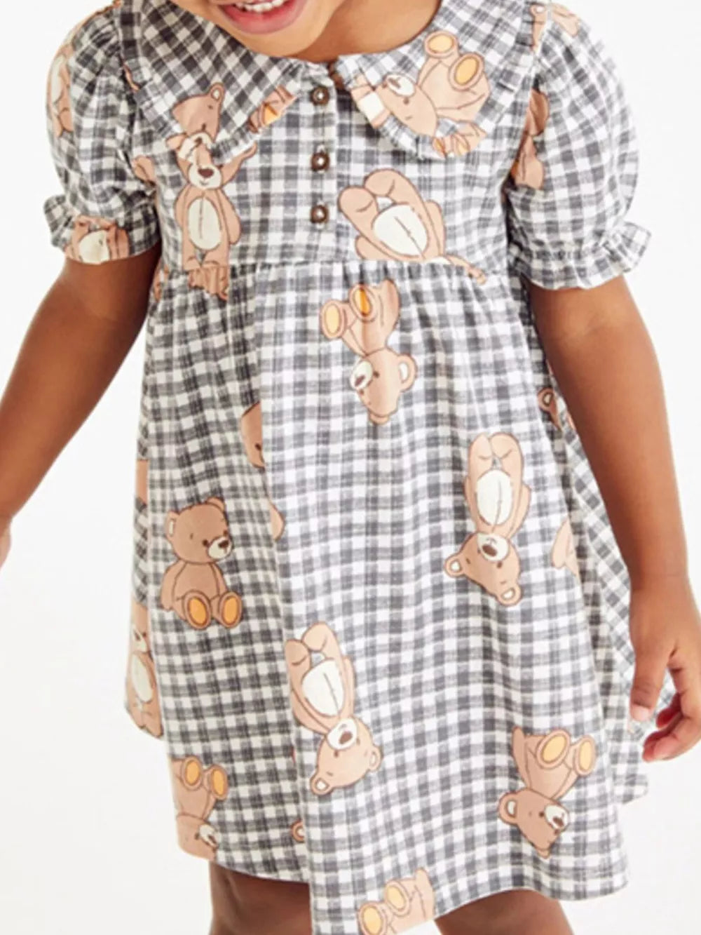 Toddler gingham dress with teddy bear print, button-down collar, and puff sleeves.