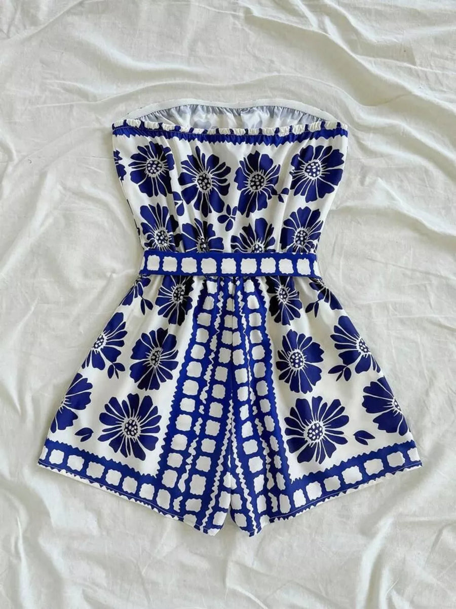 Blue floral strapless maternity romper with tie-waist and scalloped hem.