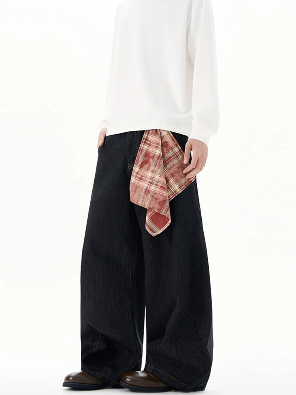 Plus size black wide-leg jeans with a red plaid scarf detail at the waist.