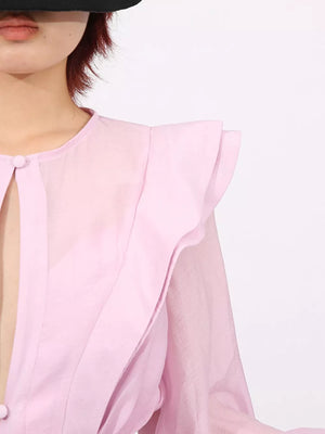 Pink tiered ruffle mini dress with button detail and sheer sleeves.
