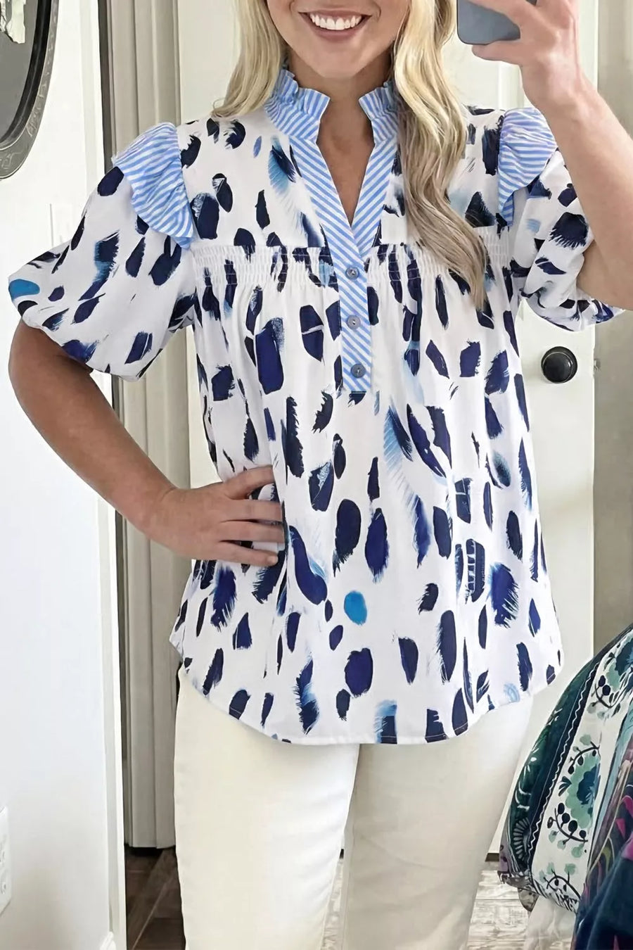 Vibrant abstract print polyester shirt with ruffled V-neck and button detail.