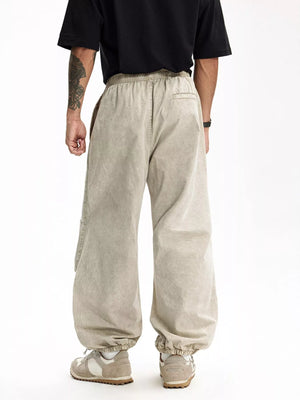Khaki relaxed fit cargo pants with elastic waistband and cuffs, featuring side pockets.