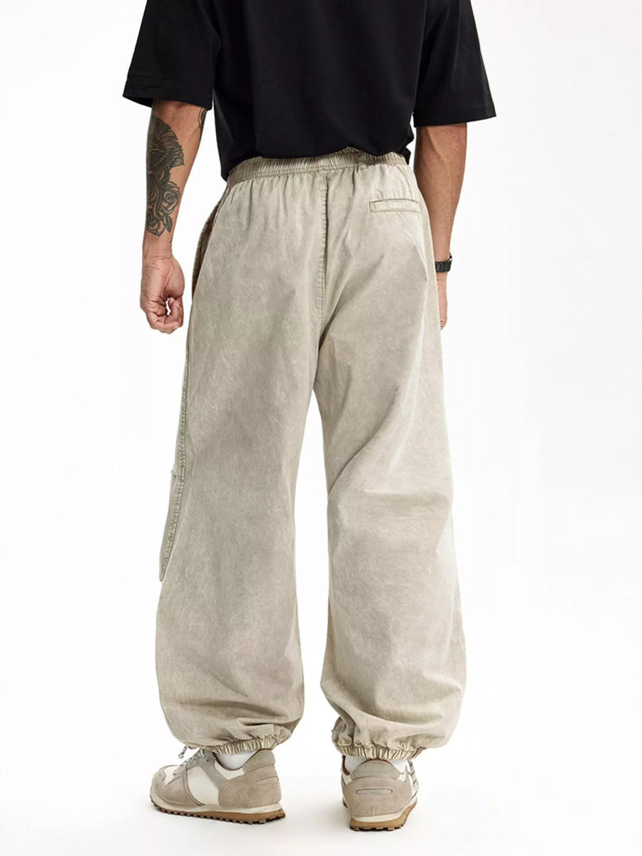 Khaki relaxed fit cargo pants with elastic waistband and cuffs, featuring side pockets.
