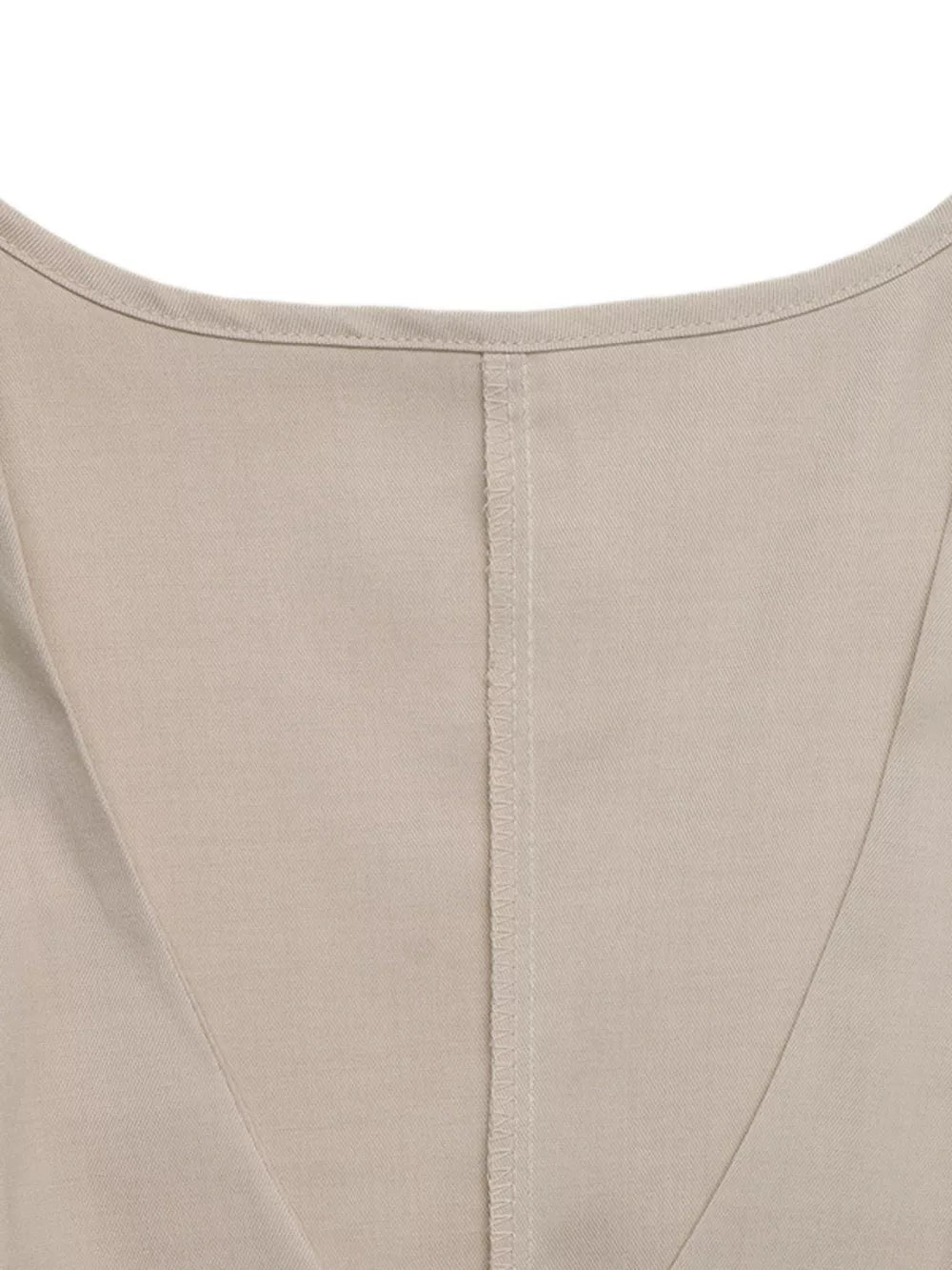 Beige sleeveless wrap top detail with V-neckline and center seam on polyester fabric.