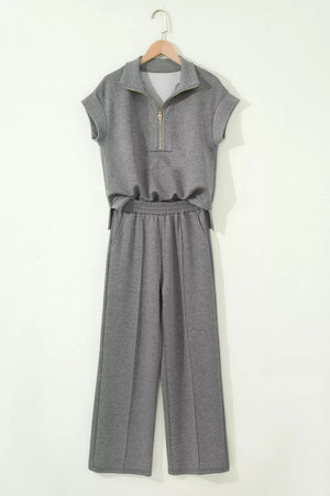 Chic dark gray half-zip polo top and wide-leg pants set with gold zipper detail.