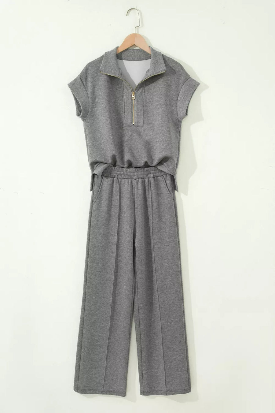 Chic dark gray half-zip polo top and wide-leg pants set with gold zipper detail.