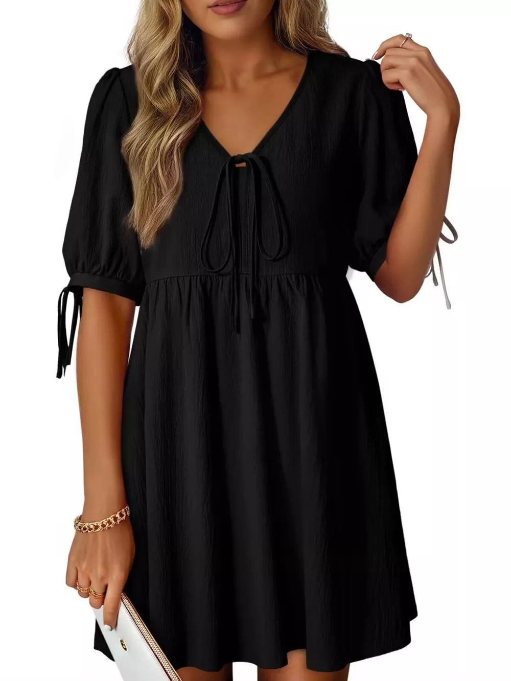 Black mini dress with tied neck, puff sleeves, and tie details on sleeves.