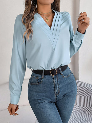 Light blue V-neckline blouse with pleated detail and long sleeves.