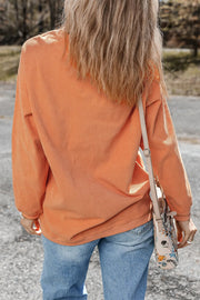 Sherbet corduroy sweatshirt with long sleeves, styled with jeans and a floral crossbody bag.