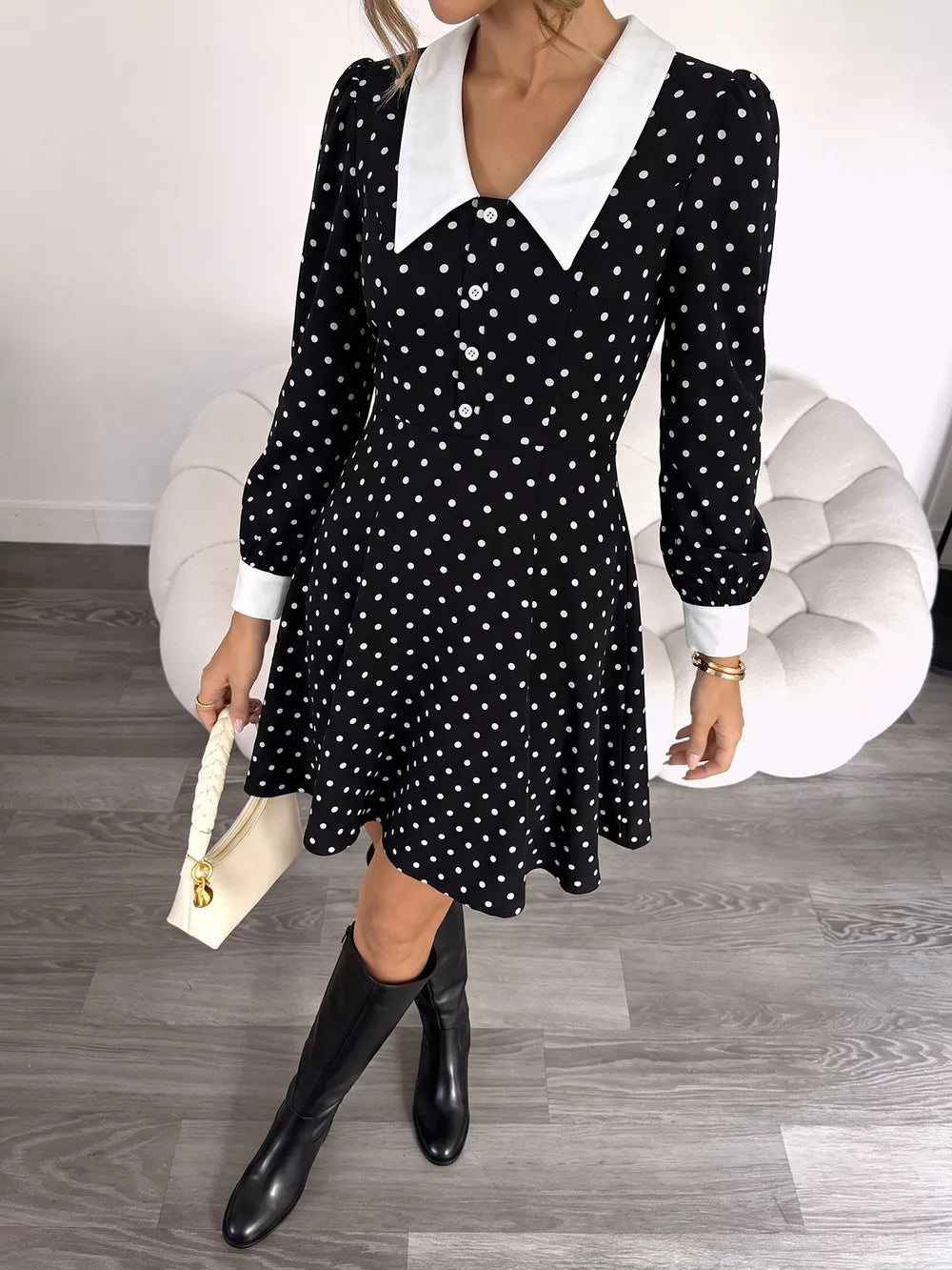 Black polka dot dress with white collar and cuffs, long sleeves, button front, and flared skirt.