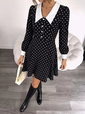 Black polka dot dress with white collar and cuffs, long sleeves, button front, and flared skirt.