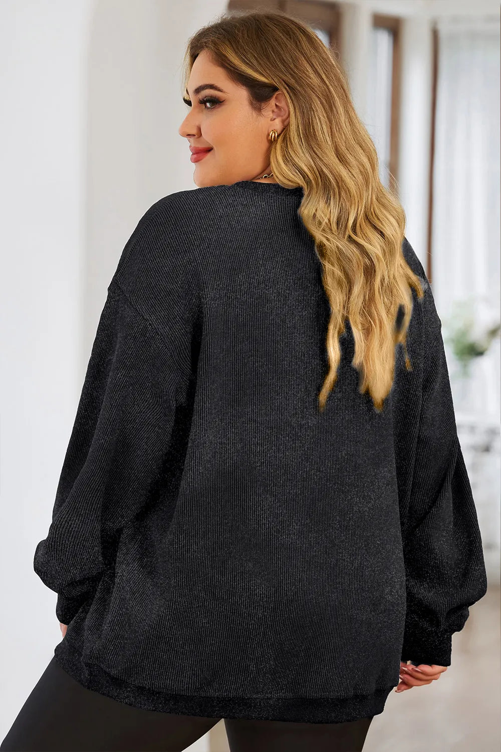 Black ribbed crewneck sweatshirt with a heart outline detail.