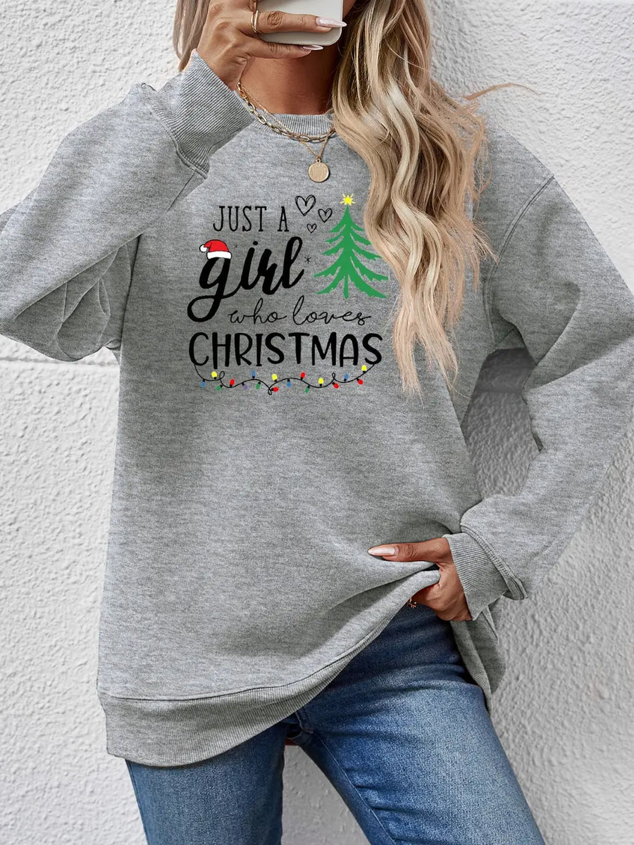 Grey crewneck sweatshirt with "Just a girl who loves Christmas" graphic and festive lights.