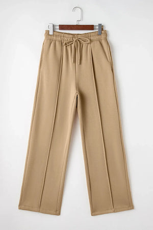 Tan wide-leg sweatpants with relaxed seam detail and drawstring waist.