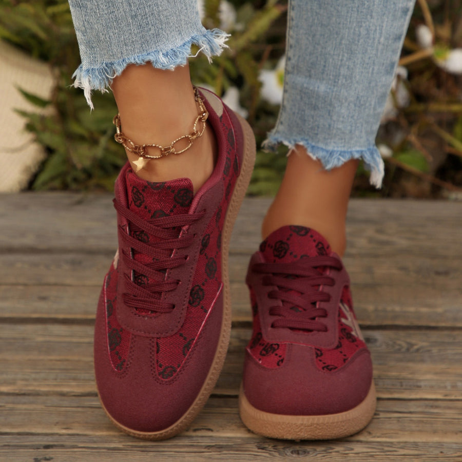 Red round toe lace up sneakers with all over pattern and brown sole.
